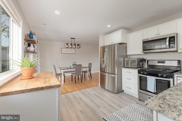 kitchen with white cabinetry, recessed lighting, stainless steel appliances, butcher block countertops, and a notable chandelier