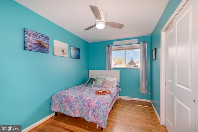 bedroom with visible vents, baseboards, a ceiling fan, and wood finished floors