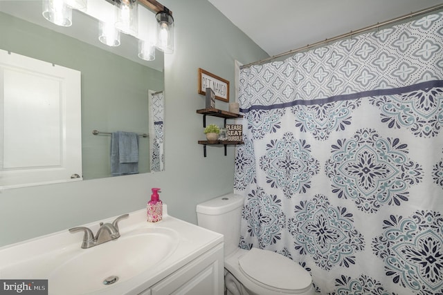 bathroom with toilet, a shower with shower curtain, and vanity