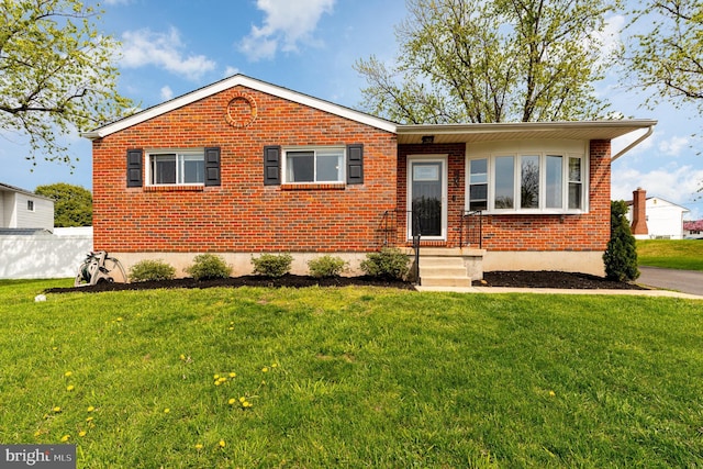 ranch-style house with a front yard and brick siding