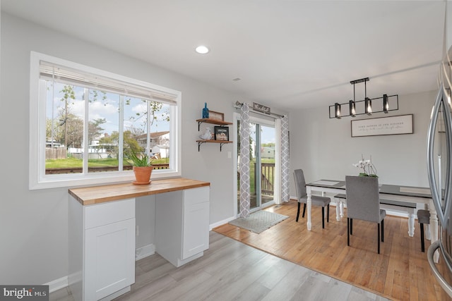 dining space featuring light wood-style flooring, baseboards, and recessed lighting