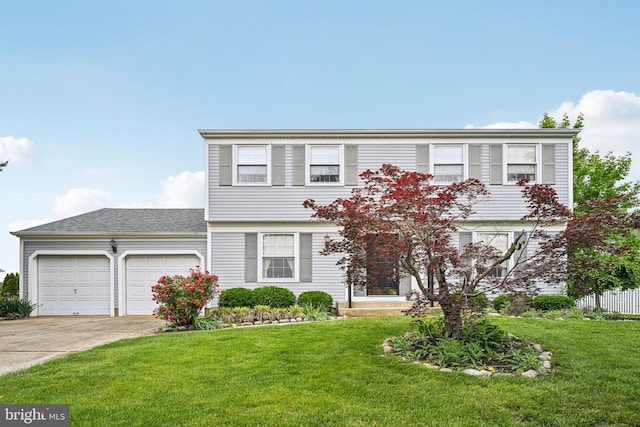 colonial inspired home with a garage, concrete driveway, and a front yard