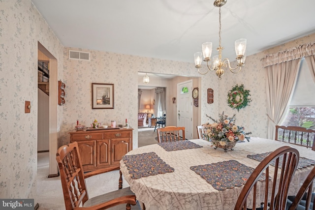 dining room with wallpapered walls, a chandelier, and light carpet
