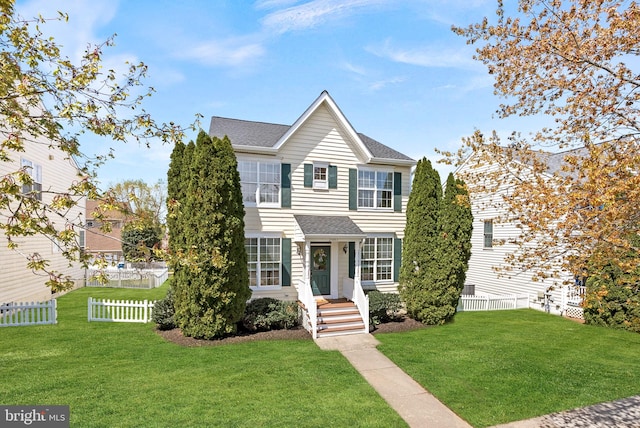 view of front of property featuring a front yard, fence, and a shingled roof