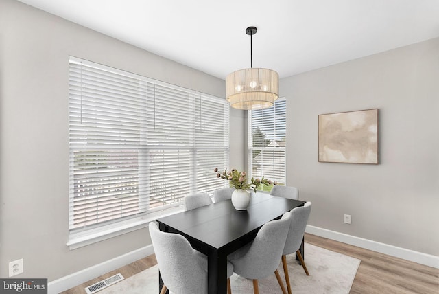 dining area featuring visible vents, baseboards, light wood-type flooring, and a healthy amount of sunlight