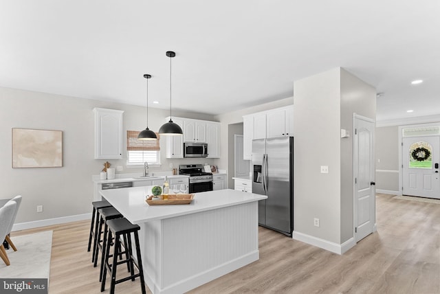 kitchen featuring light countertops, light wood-style flooring, white cabinetry, and stainless steel appliances