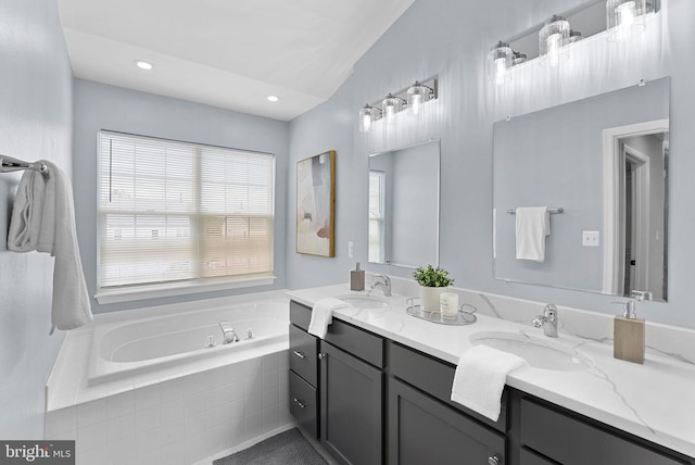 bathroom featuring a sink, a bath, double vanity, and recessed lighting