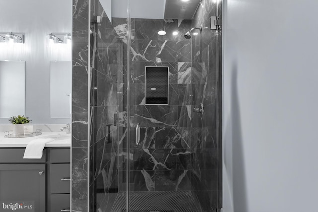 bathroom with a marble finish shower and vanity