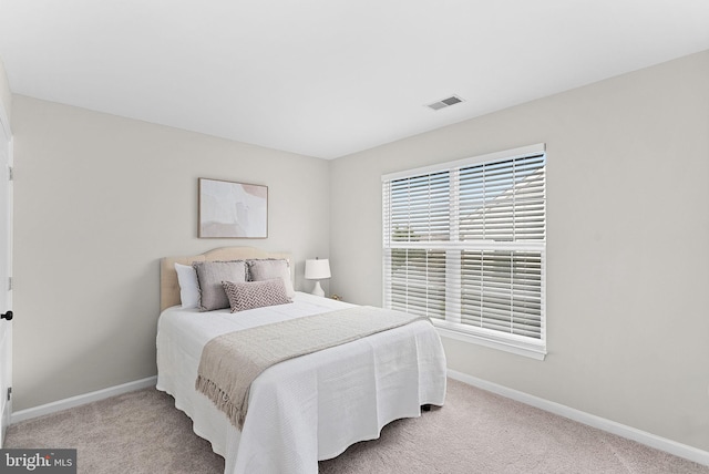 carpeted bedroom featuring visible vents and baseboards
