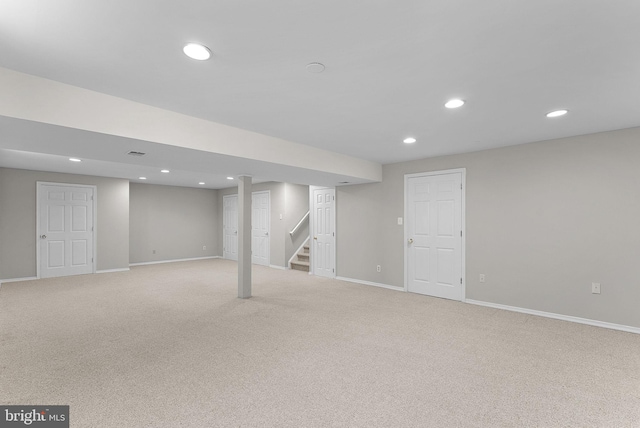 finished below grade area with light colored carpet, recessed lighting, and stairway