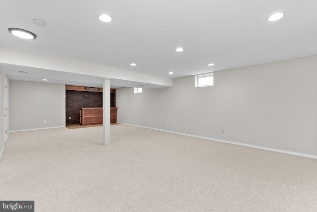 below grade area featuring baseboards, recessed lighting, and light carpet