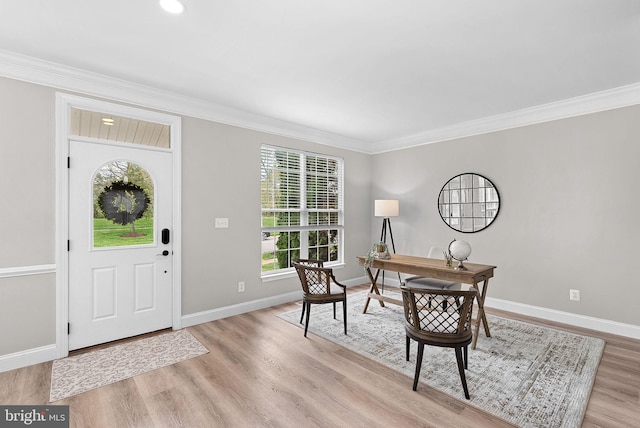 foyer with crown molding, light wood-style flooring, and baseboards