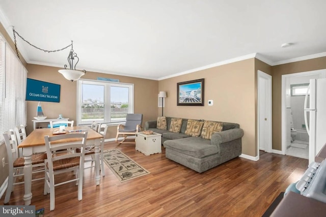living area with crown molding, baseboards, and wood finished floors