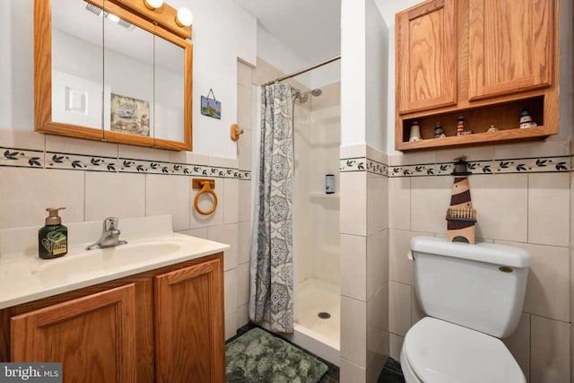 bathroom with toilet, tile walls, curtained shower, and vanity