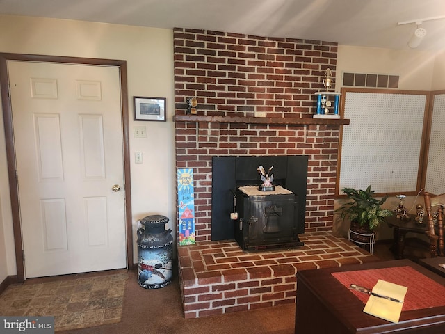 living area featuring a wood stove and visible vents