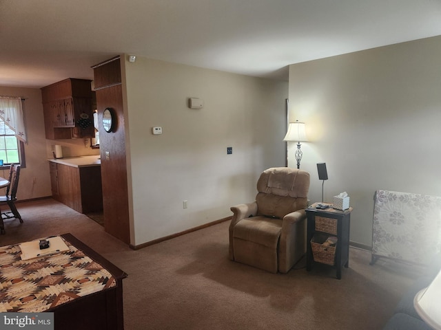living area with baseboards and light colored carpet