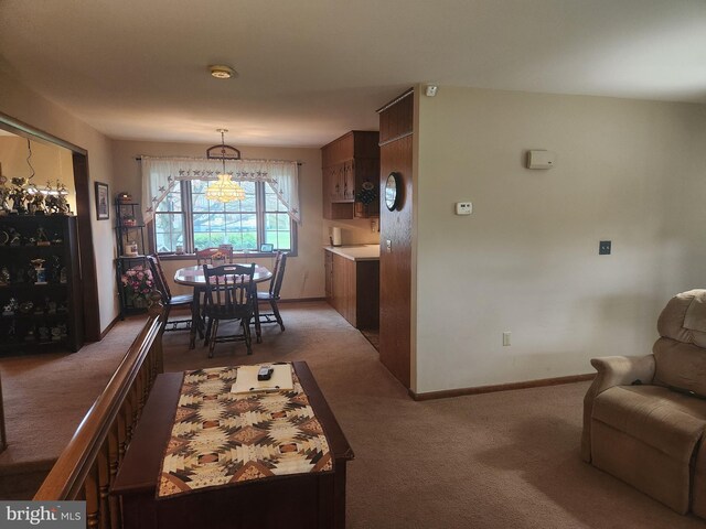 dining space with carpet flooring, baseboards, and an inviting chandelier