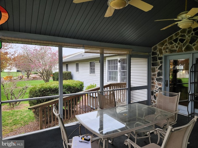 wooden deck with outdoor dining space and ceiling fan