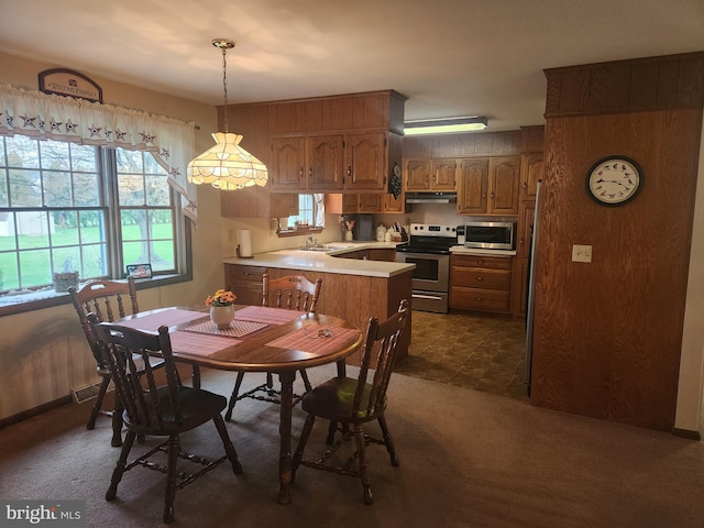 dining room with dark colored carpet and a healthy amount of sunlight