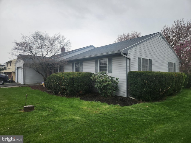 view of home's exterior with a garage, a yard, and a chimney