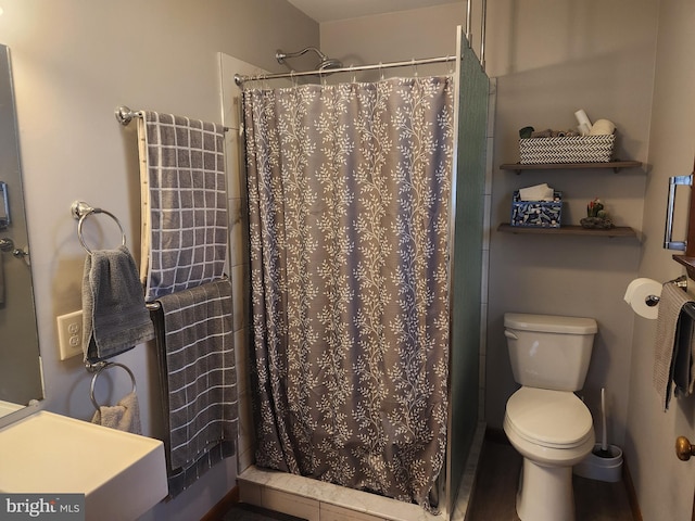 bathroom with toilet and a shower with shower curtain