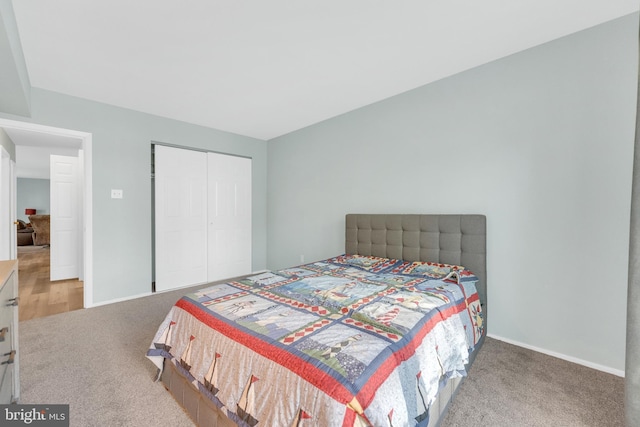 carpeted bedroom featuring baseboards and a closet
