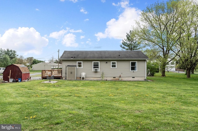 back of house with a wooden deck, crawl space, a yard, an outdoor structure, and a storage unit