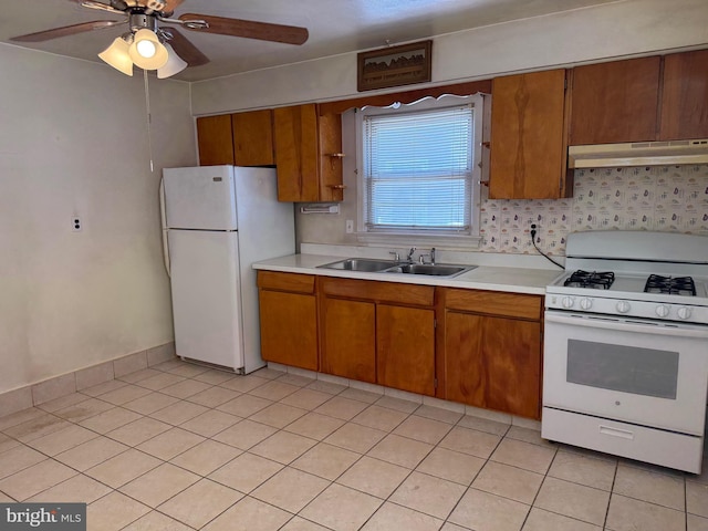 75 Unwin Dr, Hamilton, NJ 08610 - kitchen featuring white appliances, a sink, under cabinet range hood, brown cabinetry, and light countertops