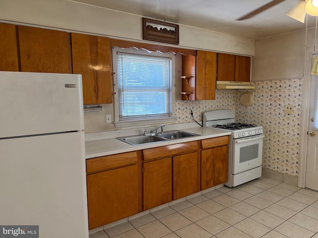 75 Unwin Dr, Hamilton, NJ 08610 - kitchen featuring white appliances, a sink, under cabinet range hood, light countertops, and brown cabinetry