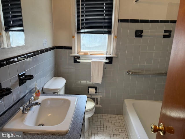 75 Unwin Dr, Hamilton, NJ 08610 - bathroom featuring a sink, tile walls, toilet, plenty of natural light, and a tub to relax in