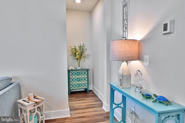 hall featuring baseboards, recessed lighting, and wood finished floors