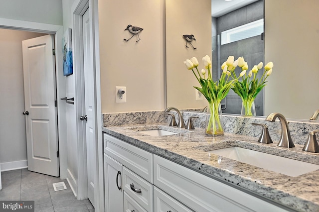 bathroom with double vanity, a sink, and tile patterned flooring