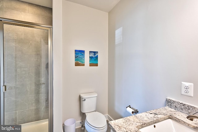 bathroom featuring vanity, baseboards, a shower stall, and toilet
