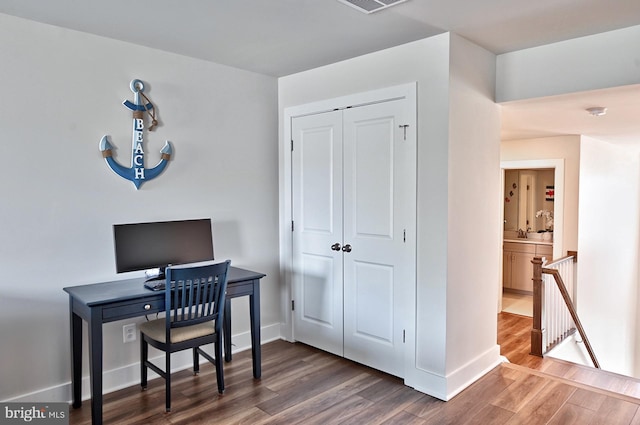 office featuring baseboards, wood finished floors, and visible vents