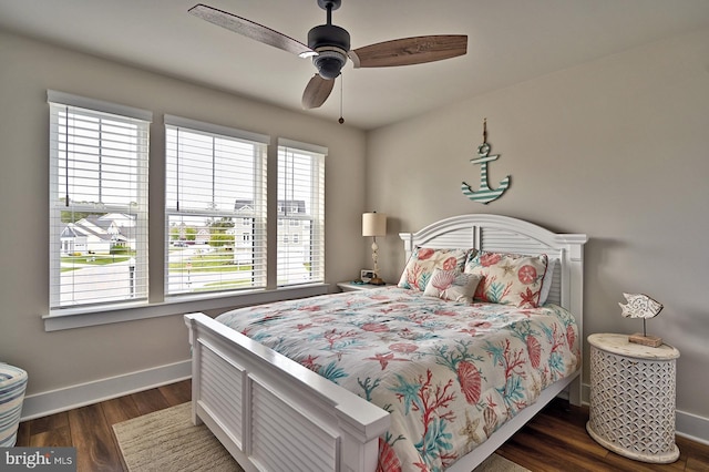 bedroom with baseboards, dark wood finished floors, multiple windows, and ceiling fan
