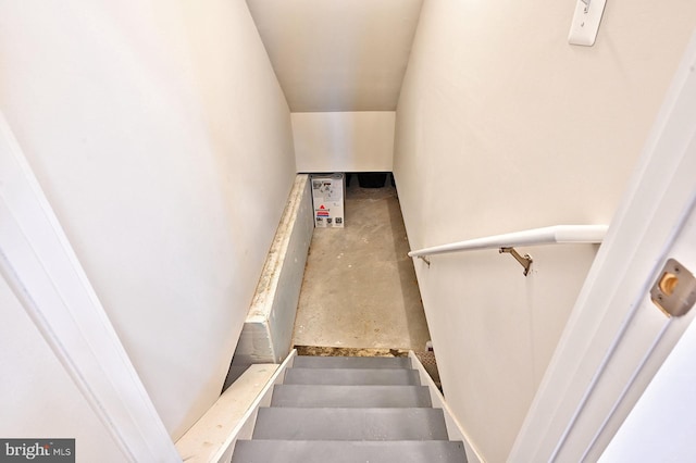staircase featuring concrete floors