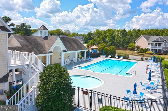 pool with fence, a patio, and stairway