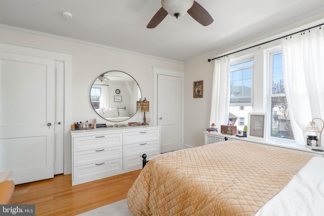 bedroom featuring a ceiling fan, light wood-style floors, and crown molding