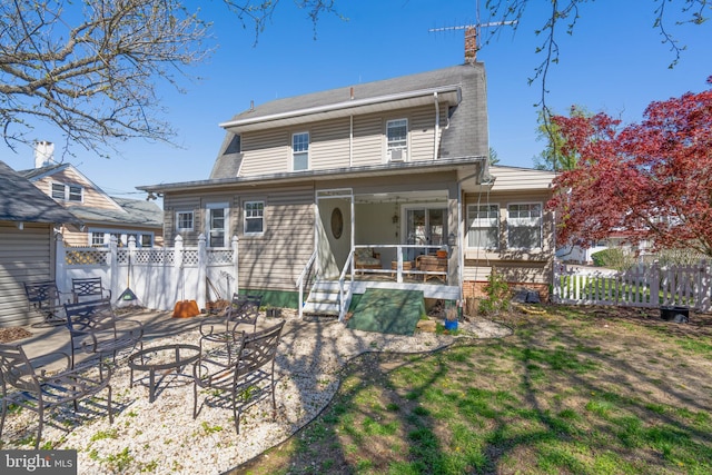 rear view of property featuring a chimney, a patio, and fence