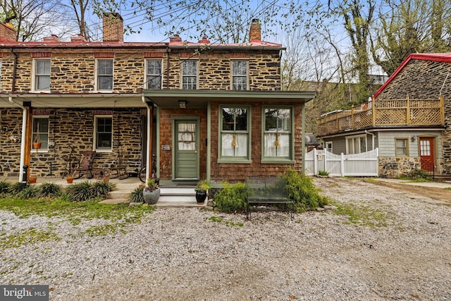 back of property with fence and a chimney