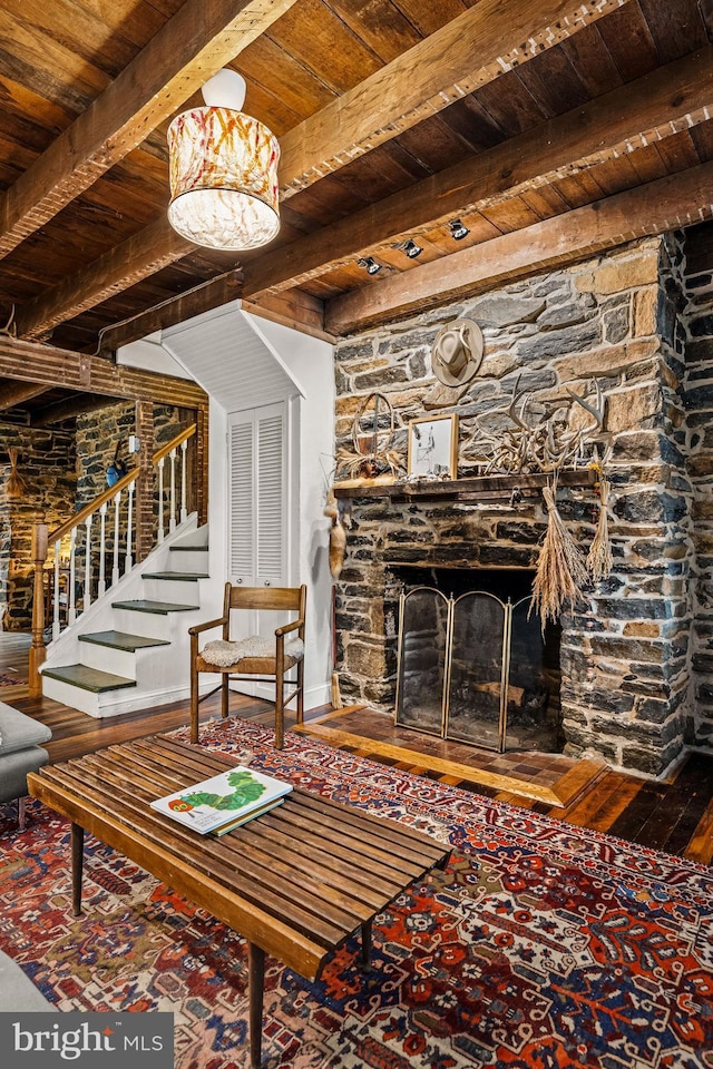living room with stairway, wooden ceiling, beamed ceiling, and a fireplace
