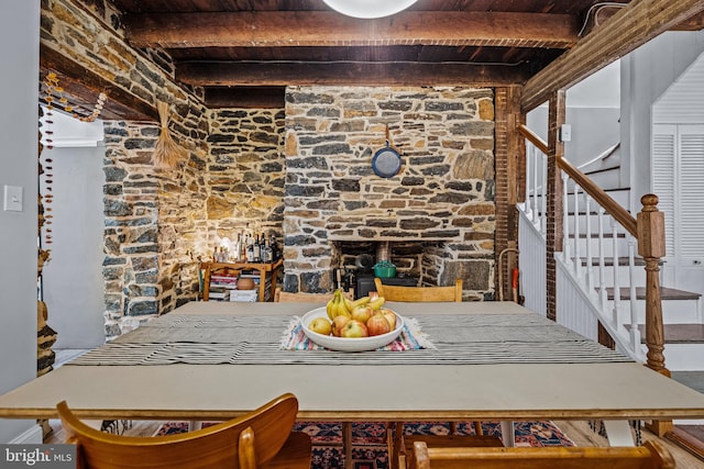 dining space featuring beamed ceiling, stairs, and wooden ceiling