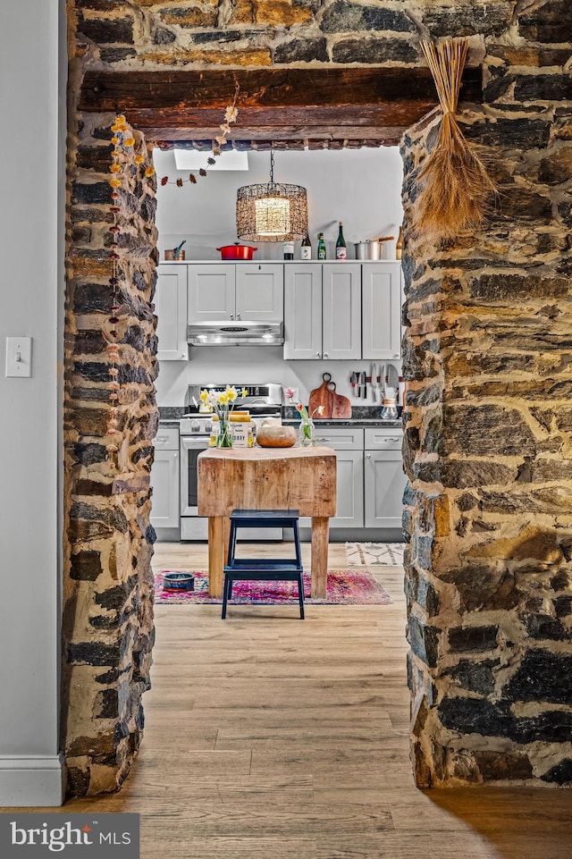 kitchen featuring a chandelier, stainless steel range with electric cooktop, light wood-style flooring, and under cabinet range hood