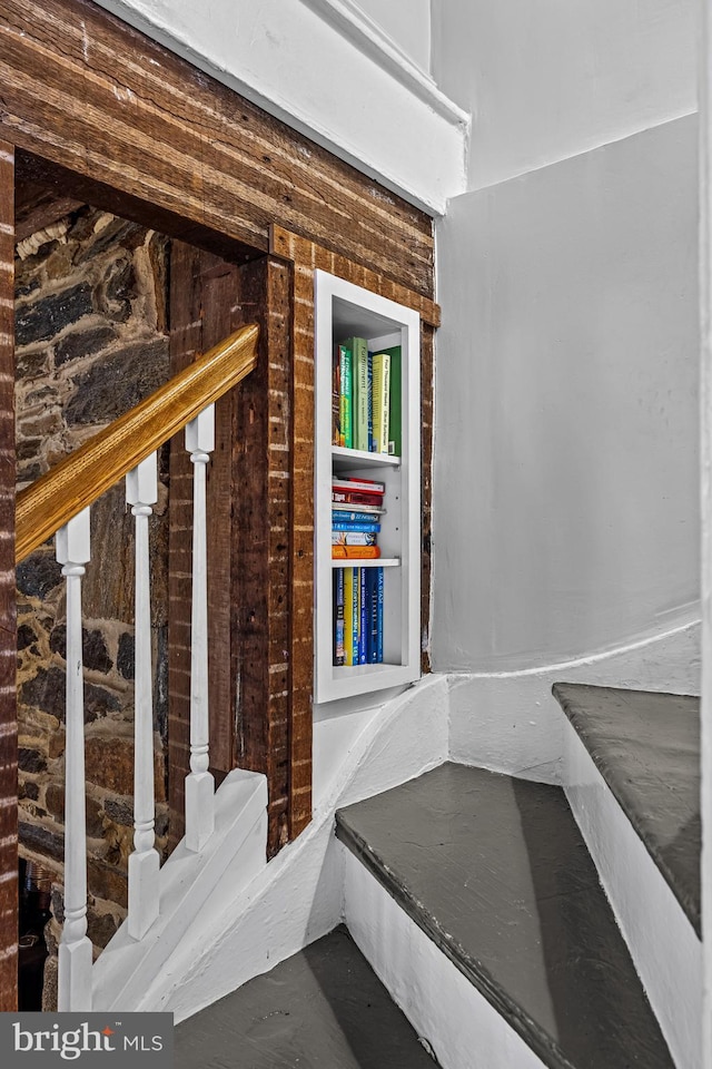 stairs featuring wood walls