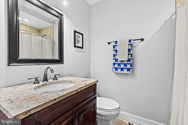 full bath with baseboards, vanity, and toilet