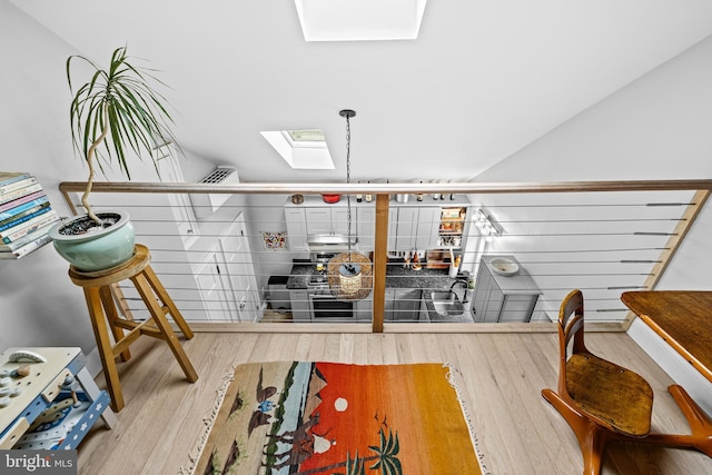 interior space featuring wood finished floors and a skylight
