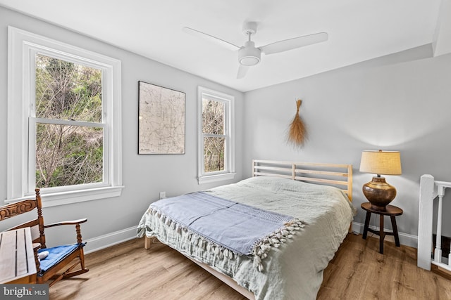 bedroom with wood finished floors, baseboards, and ceiling fan