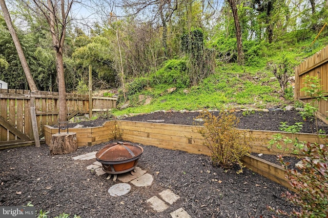 view of yard featuring fence and an outdoor fire pit
