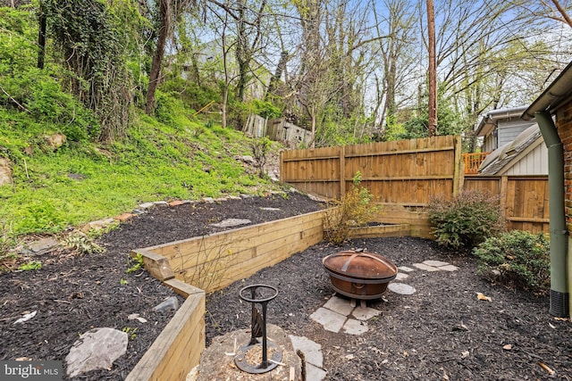 view of yard featuring fence and a fire pit