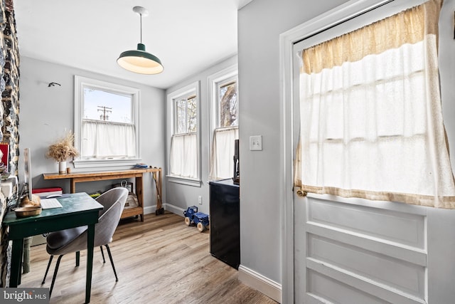 home office with light wood-style flooring and baseboards